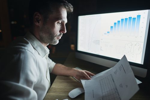 side-view-mature-man-analyzing-documents-night